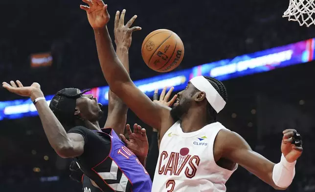 Toronto Raptors' Chris Boucher, left, and Cleveland Cavaliers' Caris LeVert (3) battle for the ball during the first half of an NBA basketball game, Wednesday, Oct. 23, 2024 in Toronto. (Frank Gunn/The Canadian Press via AP)