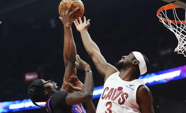 Toronto Raptors' Chris Boucher, left, and Cleveland Cavaliers' Caris LeVert (3) battle for the ball during the first half of an NBA basketball game, Wednesday, Oct. 23, 2024 in Toronto. (Frank Gunn/The Canadian Press via AP)