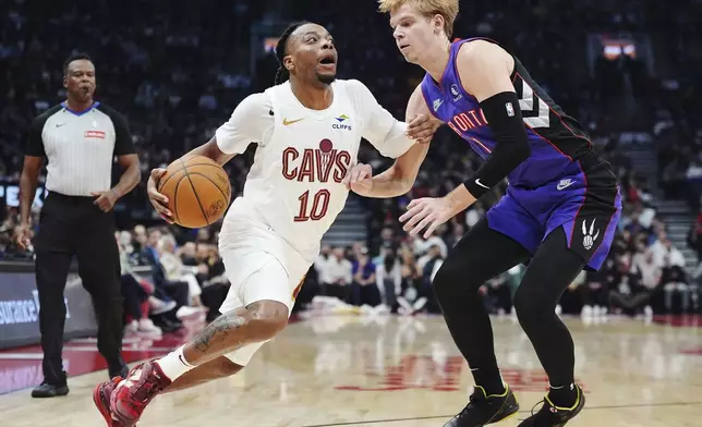 Cleveland Cavaliers' Darius Garland (10) drives as Toronto Raptors' Gradey Dick (1) defends during the first half of an NBA basketball game, Wednesday, Oct. 23, 2024 in Toronto. (Frank Gunn/The Canadian Press via AP)