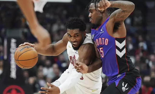 Cleveland Cavaliers' Donovan Mitchell, left, drives as Toronto Raptors' Davion Mitchell (45) defends during the first half of an NBA basketball game, Wednesday, Oct. 23, 2024 in Toronto. (Frank Gunn/The Canadian Press via AP)