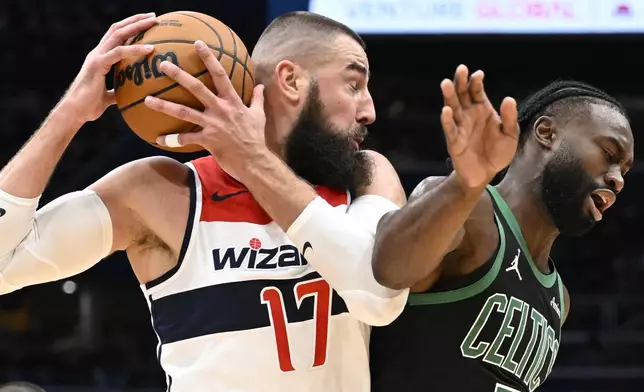 Washington Wizards center (17) grabs a rebound agains Boston Celtics guard Jaylen Brown, right, during the first half of an NBA basketball game Thursday, Oct. 24, 2024, in Washington. (AP Photo/John McDonnell)