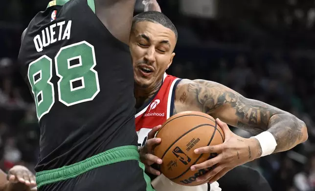 Washington Wizards forward Kyle Kuzma, right, is fouled by Boston Celtics center Neemias Queta (88) during the first half of an NBA basketball game Thursday, Oct. 24, 2024, in Washington. (AP Photo/John McDonnell)