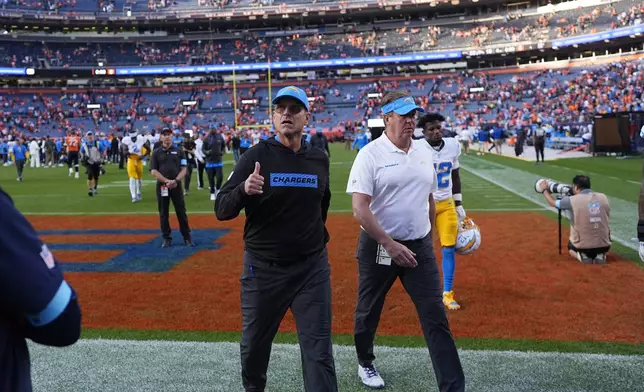 Los Angeles Chargers head coach Jim Harbaugh gestures to the crowd as he leaves the field after an NFL football game against the Denver Broncos, Sunday, Oct. 13, 2024, in Denver. (AP Photo/David Zalubowski)