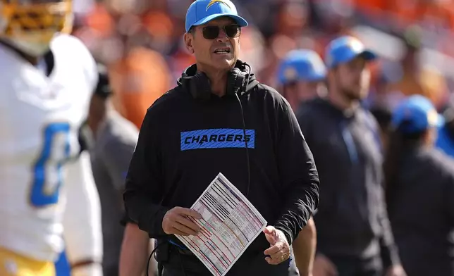 Los Angeles Chargers head coach Jim Harbaugh stands on the sideline during the first half of an NFL football game against the Denver Broncos, Sunday, Oct. 13, 2024, in Denver. (AP Photo/David Zalubowski)