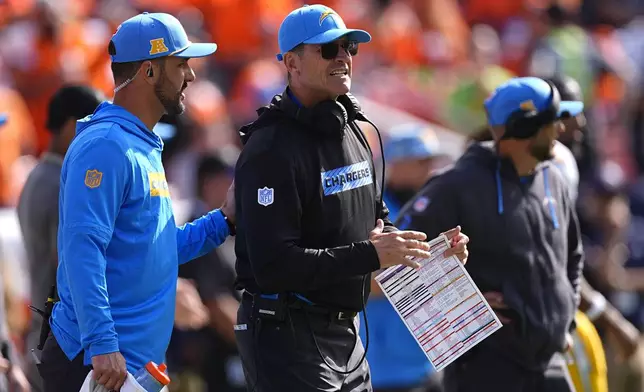 Los Angeles Chargers head coach Jim Harbaugh, center, stands on the sideline during the first half of an NFL football game against the Denver Broncos, Sunday, Oct. 13, 2024, in Denver. (AP Photo/David Zalubowski)