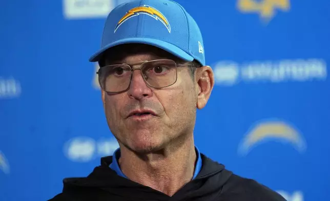 Los Angeles Chargers head coach Jim Harbaugh responds to a question during news conference after defeating the Denver Broncos in an NFL football game Sunday, Oct. 13, 2024, in Denver. (AP Photo/David Zalubowski)