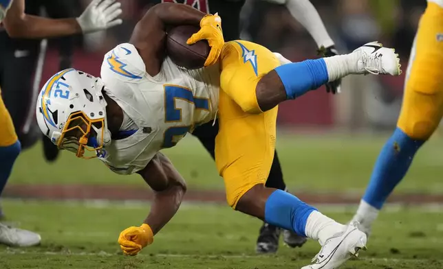 Los Angeles Chargers running back J.K. Dobbins (27) is tackled as he runs up field during the first half of an NFL football game against the Arizona Cardinals, Monday, Oct. 21, 2024, in Glendale Ariz. (AP Photo/Matt York)