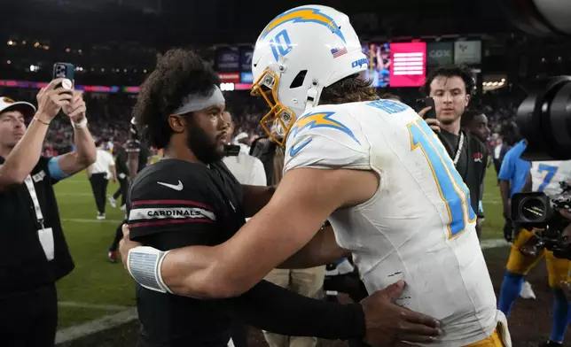 Arizona Cardinals quarterback Kyler Murray, left, talks with Los Angeles Chargers quarterback Justin Herbert (10) after an NFL football game, Monday, Oct. 21, 2024, in Glendale Ariz. (AP Photo/Matt York)