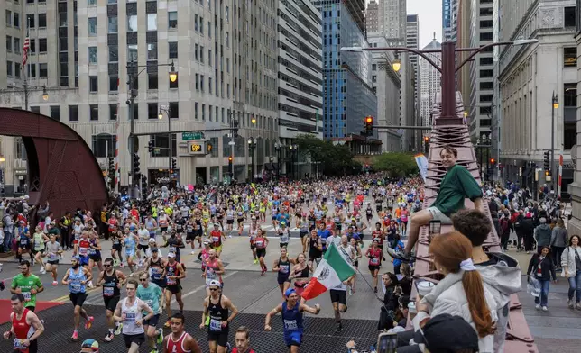 Runners cross the LaSalle Street bridge during the Chicago Marathon, Sunday, Oct. 13, 2024, in Chicago. (Armando L. Sanchez/Chicago Tribune via AP)