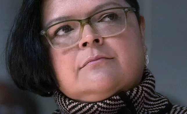 Olga Bautista, one of six nominees by Chicago Mayor Brandon Johnson to the Chicago Board of Education listens to the mayor during a news conference introducing his nominees Monday, Oct. 7, 2024, in Chicago. (AP Photo/Charles Rex Arbogast)