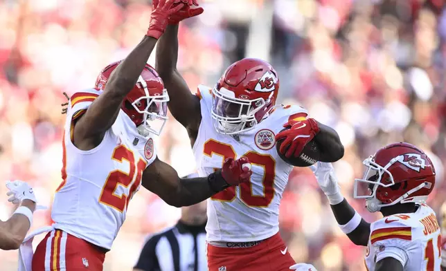 Kansas City Chiefs cornerback Christian Roland-Wallace, middle, celebrates after intercepting a pass with safety Justin Reid, left, and safety Nazeeh Johnson during the second half of an NFL football game in Santa Clara, Calif., Sunday, Oct. 20, 2024. (AP Photo/Eakin Howard)