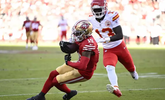 San Francisco 49ers wide receiver Jacob Cowing (19) catches a pass against Kansas City Chiefs safety Nazeeh Johnson (13) during the second half of an NFL football game in Santa Clara, Calif., Sunday, Oct. 20, 2024. (AP Photo/Eakin Howard)