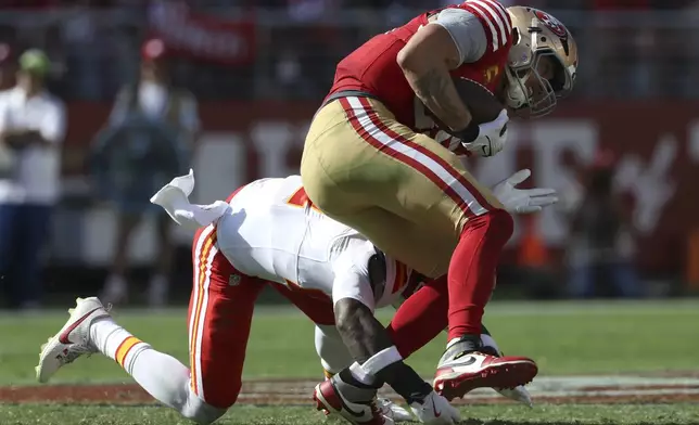 San Francisco 49ers tight end George Kittle, right, runs against Kansas City Chiefs safety Chamarri Conner during the first half of an NFL football game in Santa Clara, Calif., Sunday, Oct. 20, 2024. (AP Photo/Jed Jacobsohn)