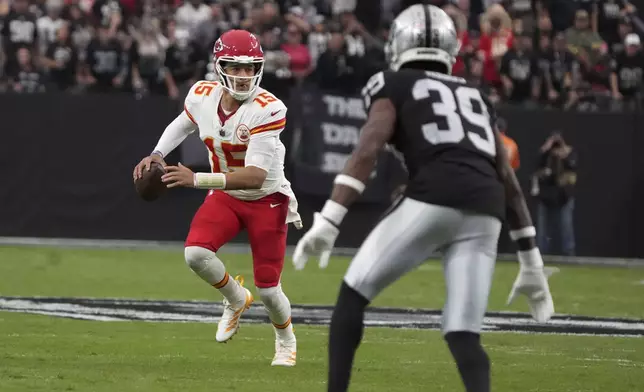 Kansas City Chiefs quarterback Patrick Mahomes (15) scrambles as Las Vegas Raiders cornerback Nate Hobbs (39) defends during the first half of an NFL football game Sunday, Oct. 27, 2024, in Las Vegas. (AP Photo/Rick Scuteri)