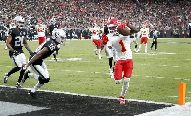 Kansas City Chiefs wide receiver Xavier Worthy (1) gets past Las Vegas Raiders cornerback Jack Jones (18) to score a touchdown during the second half of an NFL football game Sunday, Oct. 27, 2024, in Las Vegas. (Steve Marcus/Las Vegas Sun via AP)