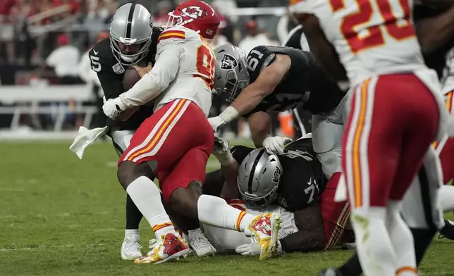 Las Vegas Raiders quarterback Gardner Minshew (15) is stopped by Kansas City Chiefs defensive tackle Tershawn Wharton (98) during the second half of an NFL football game Sunday, Oct. 27, 2024, in Las Vegas. (AP Photo/John Locher)