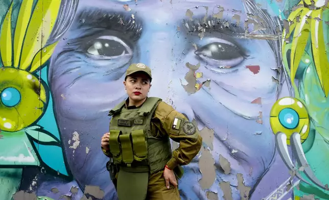 A police officer stands outside the Barros Arana National Boarding School as authorities respond to a fire in Santiago Chile, Wednesday, Oct. 23, 2024. (AP Photo/Esteban Felix)