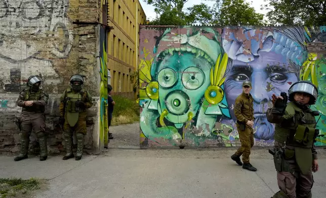 Security forces stand outside the Barros Arana National Boarding School after a fire at the school in Santiago Chile, Wednesday, Oct. 23, 2024. (AP Photo/Esteban Felix)