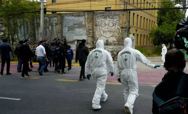 Authorities head inside the Barros Arana National Boarding School after a fire in Santiago Chile, Wednesday, Oct. 23, 2024. (AP Photo/Esteban Felix)