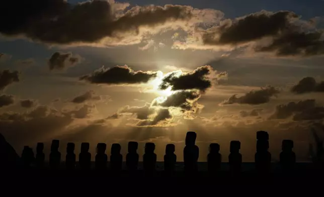 The sun rises behind moais statues on Ahu Tongariki, Rapa Nui, or Easter Island, early Thursday, Oct. 3, 2024. Each monolithic human figure carved centuries ago by this remote Pacific island's Rapanui people represents an ancestor. (AP Photo/Esteban Felix)