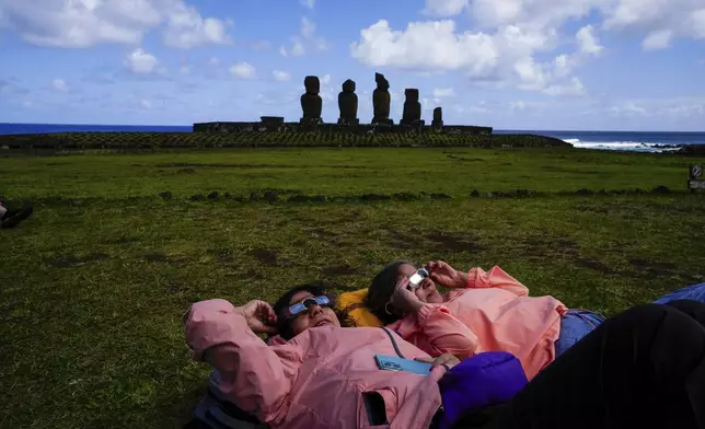 People watch the annular solar eclipse in Tahai, Rapa Nui, or Easter Island, Chile, Wednesday, Oct. 2, 2024. (AP Photo/Esteban Felix)