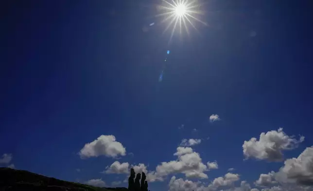 Stone statues known as Moai stand during an annular solar eclipse in Tahai, Rapa Nui, or Easter Island, Chile, Wednesday, Oct. 2, 2024. (AP Photo/Esteban Felix)