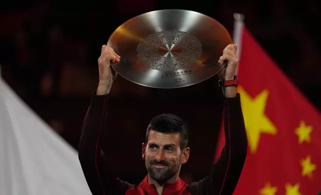 Novak Djokovic of Serbia holds ups silver medal after losing the men's singles finals match to Jannik Sinner of Italy for the Shanghai Masters tennis tournament at Qizhong Forest Sports City Tennis Center in Shanghai, China, Sunday, Oct. 13, 2024. (AP Photo/Andy Wong)