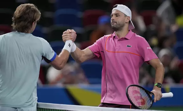 Grigor Dimitrov of Bulgaria, right, is congratulated by Zizou Bergs of Belgium after winning in the men's singles second round match in the Shanghai Masters tennis tournament at Qizhong Forest Sports City Tennis Center in Shanghai, China, Monday, Oct. 7, 2024. (AP Photo/Andy Wong)