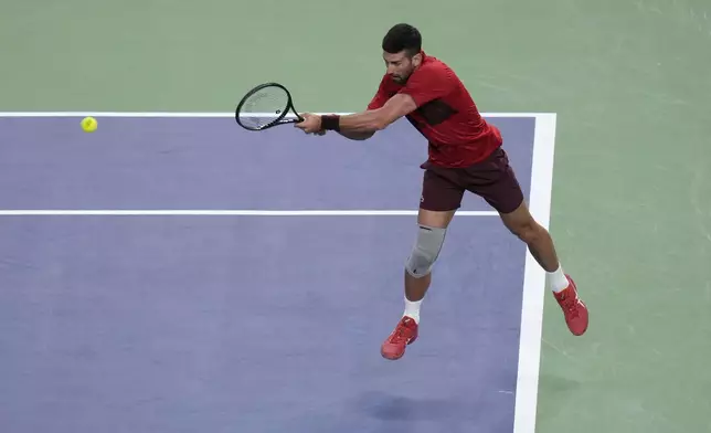 Novak Djokovic of Serbia plays a backhand return against Flavio Cobolli of Italy during the men's singles third round match in the Shanghai Masters tennis tournament at Qizhong Forest Sports City Tennis Center in Shanghai, China, Tuesday, Oct. 8, 2024. (AP Photo/Andy Wong)