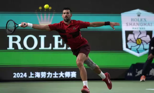 Novak Djokovic of Serbia plays a forehand return against Flavio Cobolli of Italy during the men's singles third round match in the Shanghai Masters tennis tournament at Qizhong Forest Sports City Tennis Center in Shanghai, China, Tuesday, Oct. 8, 2024. (AP Photo/Andy Wong)