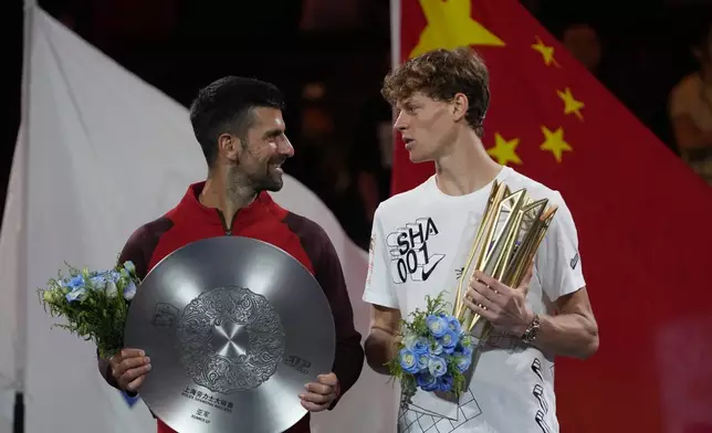 Jannik Sinner of Italy, right, chats with Novak Djokovic of Serbia during a trophy ceremony after their men's singles finals match for the Shanghai Masters tennis tournament at Qizhong Forest Sports City Tennis Center in Shanghai, China, Sunday, Oct. 13, 2024. (AP Photo/Andy Wong)