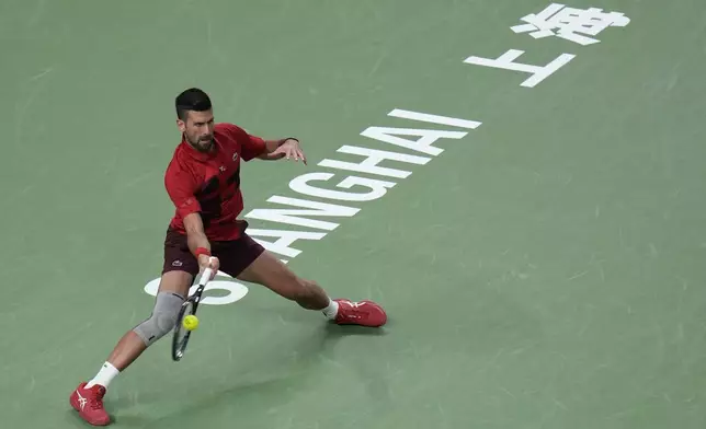 Novak Djokovic of Serbia plays a forehand return against Flavio Cobolli of Italy during the men's singles third round match in the Shanghai Masters tennis tournament at Qizhong Forest Sports City Tennis Center in Shanghai, China, Tuesday, Oct. 8, 2024. (AP Photo/Andy Wong)