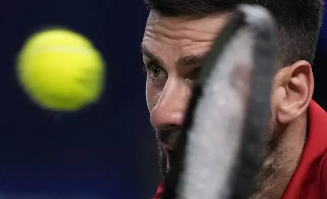 Novak Djokovic of Serbia plays a backhand return against Flavio Cobolli of Italy during the men's singles third round match in the Shanghai Masters tennis tournament at Qizhong Forest Sports City Tennis Center in Shanghai, China, Tuesday, Oct. 8, 2024. (AP Photo/Andy Wong)