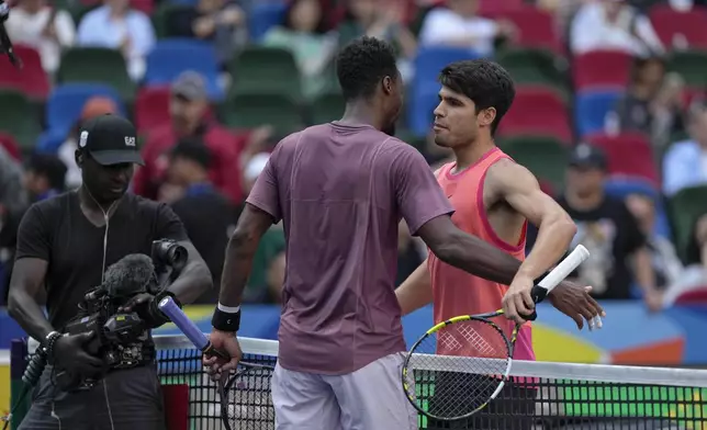 Carlos Alcaraz of Spain is congratulated by Gael Monfils of France after winning in the men's singles fourth round match of the Shanghai Masters tennis tournament at Qizhong Forest Sports City Tennis Center in Shanghai, China, Wednesday, Oct. 9, 2024. (AP Photo/Andy Wong)