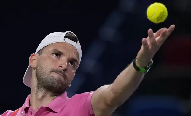 Grigor Dimitrov of Bulgaria tosses the ball to serve against Zizou Bergs of Belgium during the men's singles second round match in the Shanghai Masters tennis tournament at Qizhong Forest Sports City Tennis Center in Shanghai, China, Monday, Oct. 7, 2024. (AP Photo/Andy Wong)