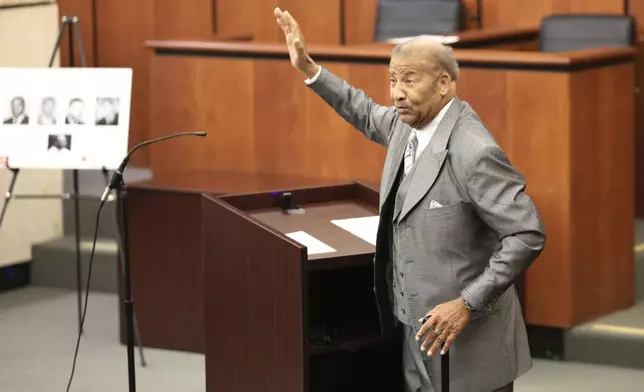 Simon Bouie waves to his family during a hearing where his record was cleared after he was arrested in 1960 for sitting at an all-white South Carolina lunch counter on Friday, Oct. 25, 2024, in Columbia, S.C. (AP Photo/Jeffrey Collins)