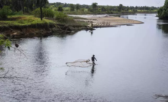 FILE - A fisherman casts his net in a lake polluted by oil on the outskirts of Moanda, western Democratic Republic of Congo, Dec. 23, 2023. (AP Photo/Mosa'ab Elshamy, File)