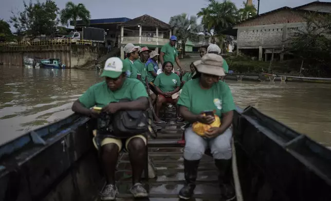 A group of women, part of Asociacion Nuestra Casa Comun, or Our Community House Association, head by boat to reforest an area destroyed by illegal mining, in Paimado, Colombia, Tuesday, Sept. 24, 2024. (AP Photo/Ivan Valencia)