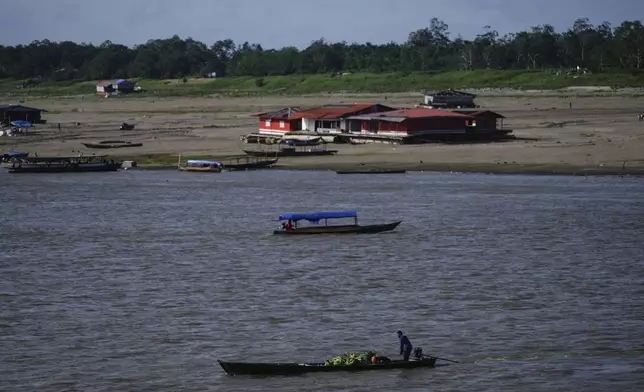 Boats maneuver low water levels amid a drought on the Amazon River, at a port that connects Colombia with Peru, in Leticia, Colombia, Sunday, Oct. 20, 2024. (AP Photo/Ivan Valencia)