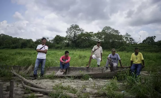 People from the Tikuna Indigenous community wait to receive aid from a nonprofit amid a drought on Amazon River in Loma Linda, near Leticia, Colombia, Sunday, Oct. 20, 2024. (AP Photo/Ivan Valencia)