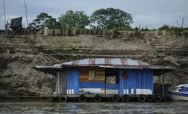 A houseboat floats on low levels of the Amazon River amid a drought in Leticia, Colombia, Sunday, Oct. 20, 2024. (AP Photo/Ivan Valencia)