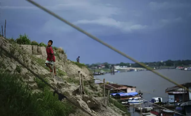 A boy climbs a hill near a low Amazon River due to the drought, in Leticia, Colombia, Sunday, Oct. 20, 2024. (AP Photo/Ivan Valencia