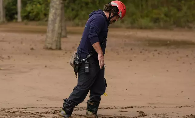 FILE - A fireman walks through mud as they search for victims of flash flooding in the aftermath of Hurricane Helene, Oct. 1, 2024, in Swannanoa, N.C. (AP Photo/Mike Stewart, File)