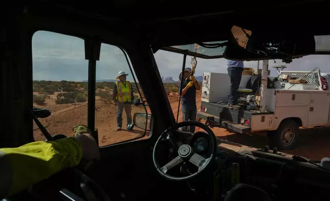 Robert Black, left, with the Navajo Tribal Utility Authority, supervises as a volunteer crew lifts a power line pole, Tuesday, Oct. 8, 2024, on the Navajo Nation in Halchita, Utah. (AP Photo/Joshua A. Bickel)