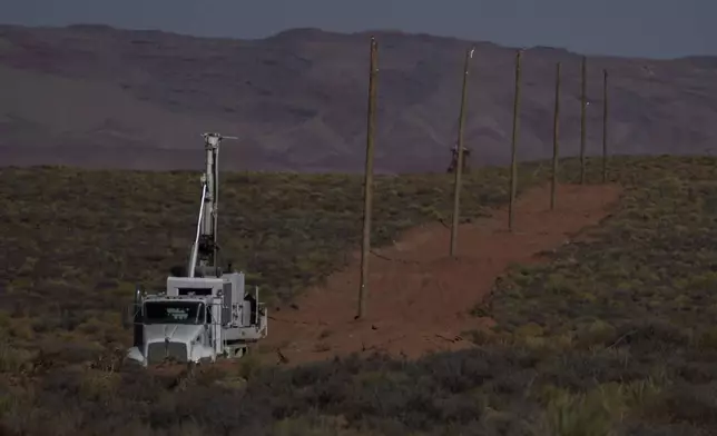 A crew with the Navajo Tribal Utility Authority installs power poles, Wednesday, Oct. 9, 2024, on the Navajo Nation in Halchita, Utah. (AP Photo/Joshua A. Bickel)