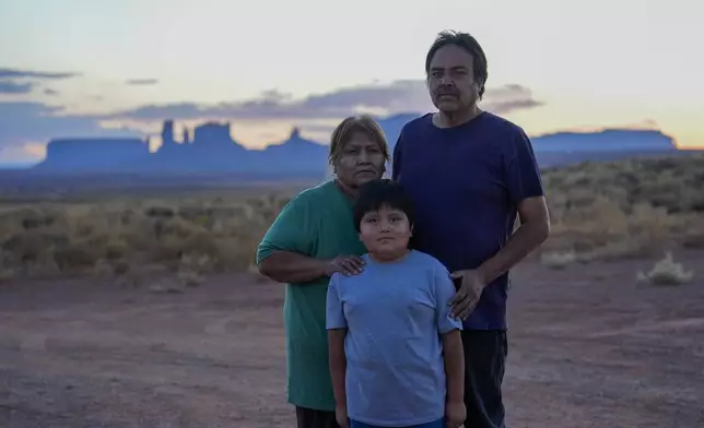 Lorraine Black, left and Ricky Gillis, right, pose for a portrait with their grandson, Liam Gillis, 7, outside their home, Wednesday, Oct. 9, 2024, on the Navajo Nation in Halchita, Utah. (AP Photo/Joshua A. Bickel)