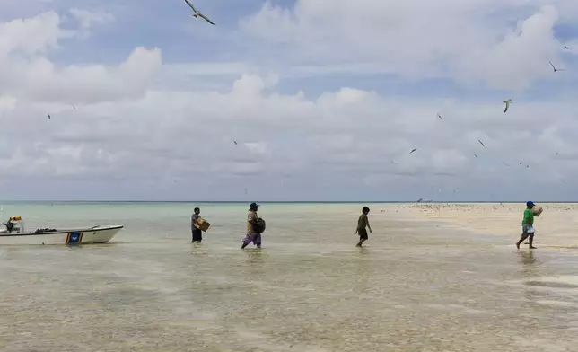 Metfidza Marino, from left, Tony Chayum, Mouwanes Patris Bismark and Aarson Aaron help the Hatohobei State Rangers bring goods from the speed boats to the ranger station and living quarters on Helen Island, Palau, July 17, 2024. (AP Photo/Yannick Peterhans)