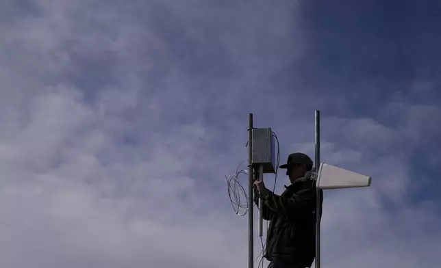 FILE - Carver Cammans installs cloud seeding equipment, Dec. 3, 2022, in Lyons, Colo. (AP Photo/Brittany Peterson, File)