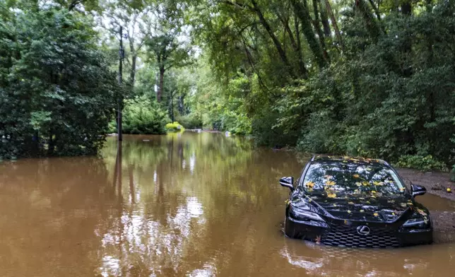 FILE - A partially submerged vehicle sits in floodwater from after Hurricane Helene passed the area, Sept 27, 2024, in Atlanta. (AP Photo/Jason Allen, File)