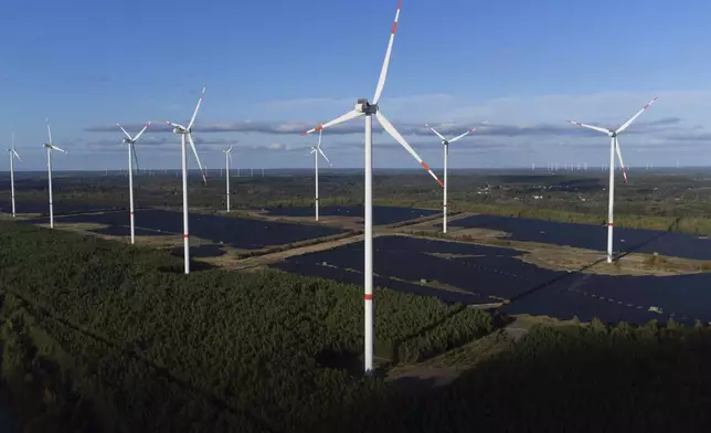 Wind turbines operate at the Klettwitz Nord solar energy park near Klettwitz, Germany, Tuesday, Oct. 15, 2024. (AP Photo/Matthias Schrader)